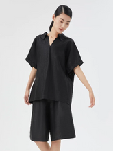 a lady in a black Xiang Yun Silk Shirt with matching shorts